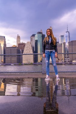 Brooklyn Parkı 'ndan Brooklyn Köprüsü' nün büyülü akşam mor gün batımının keyfini çıkaran seksi ızgara. Hudson Nehri 'nin diğer yakasında daha aşağı Manhattan manzaralı..