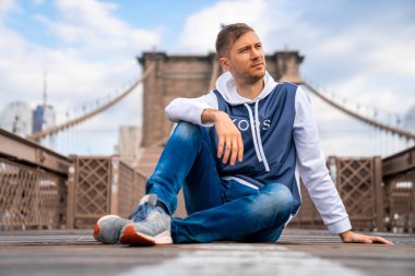Manhattan manzaralı boş Brooklyn Köprüsü 'nün keyfini çıkaran genç adam..