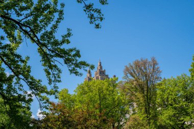 New York 'taki Central Park sıcak güneşli bir günde gökdelenlerle çevrili.