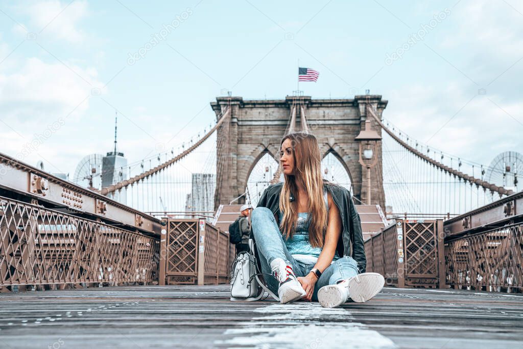 Young sexy girl enjoying empty Brooklyn Bridge with a magical Manhattan island view.