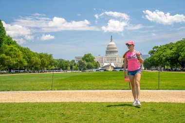 Washington, DC 'de. 10 Mayıs 2019. Washington, DC 'deki Kongre Binası' nda çimlerde yürüyen genç bir kız..