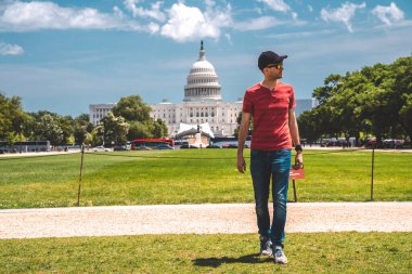 Washington, DC 'deki Kongre Binası' nın çimlerin üzerinde yürüyen genç adam..