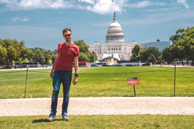 Washington, DC 'deki Kongre Binası' nın çimlerin üzerinde yürüyen genç adam..
