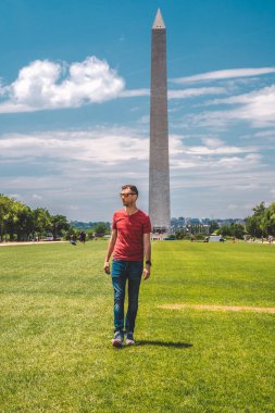 Güneşli bir günde Washington yakınlarında mavi gökyüzü arka planıyla Washington şehrini keşfeden genç adam..