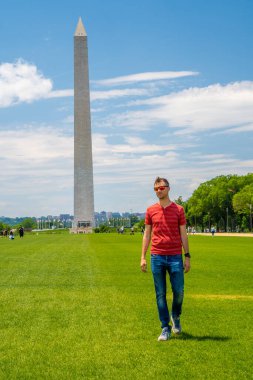 Güneşli bir günde Washington yakınlarında mavi gökyüzü arka planıyla Washington şehrini keşfeden genç adam..