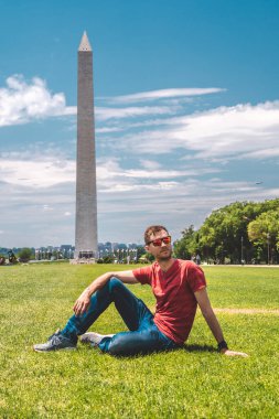Güneşli bir günde Washington yakınlarında mavi gökyüzü arka planıyla Washington şehrini keşfeden genç adam..
