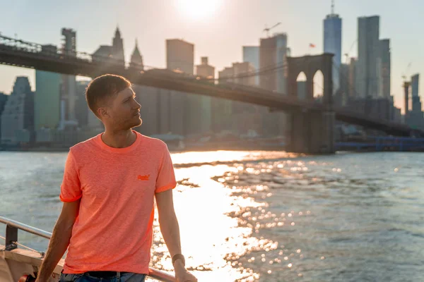 Genç Adam Brooklyn Köprüsünün Altından Geçen Feribottan Günbatımının Keyfini Çıkarıyor — Stok fotoğraf