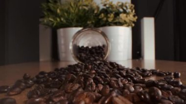 Kavrulmuş kahve çekirdekleri. Kavrulmuş kahve çekirdekleri yavaşça daireler çiziyor. Kavrulmuş kahve fasülyesi arka planı, üst manzara..