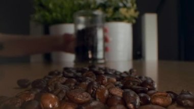 Kavrulmuş kahve çekirdekleri. Kavrulmuş kahve çekirdekleri yavaşça daireler çiziyor. Kavrulmuş kahve fasülyesi arka planı, üst manzara..