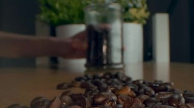 Kavrulmuş kahve çekirdekleri. Kavrulmuş kahve çekirdekleri yavaşça daireler çiziyor. Kavrulmuş kahve fasülyesi arka planı, üst manzara..