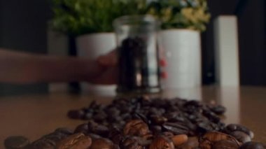 Kavrulmuş kahve çekirdekleri. Kavrulmuş kahve çekirdekleri yavaşça daireler çiziyor. Kavrulmuş kahve fasülyesi arka planı, üst manzara..