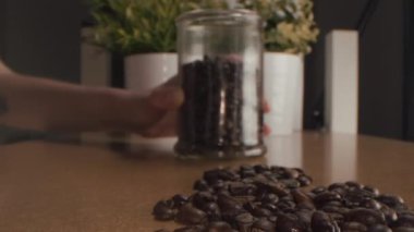 Kavrulmuş kahve çekirdekleri. Kavrulmuş kahve çekirdekleri yavaşça daireler çiziyor. Kavrulmuş kahve fasülyesi arka planı, üst manzara..