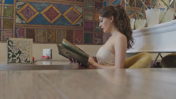 Das Mädchen liest das Menü — Stockvideo