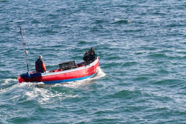 Geleneksel bir balıkçı teknesiyle yengeç ve ıstakoz kapları toplamaya giden bir Cornish balıkçısı.