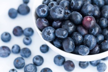Taze, organik yaban mersini izole bir beyaz zemin üzerinde bir bowlful üzerine yukarıdan bakıyor 