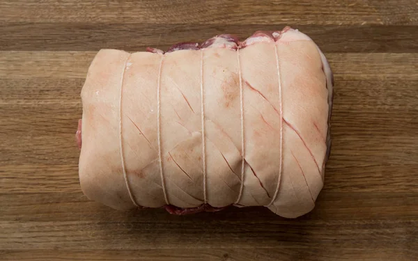 A raw Pork Shoulder cut of meat tied and scored