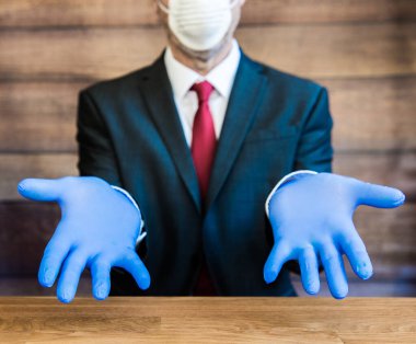 A concept of a Global shortage of ppe including blue surgical gloves and face mask with a Doctor, Businessman or employer wearing ppe and feeling frustrated clipart