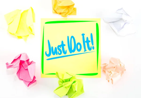 A yellow sticky note with the inspirational quote encouraging people to Just Do It rather than thinking and delaying.