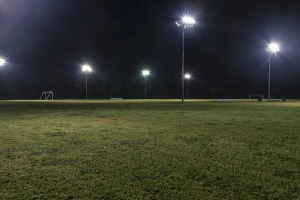 Campos de fútbol atléticos vacíos por la noche con luces encendidas —  Fotos de Stock