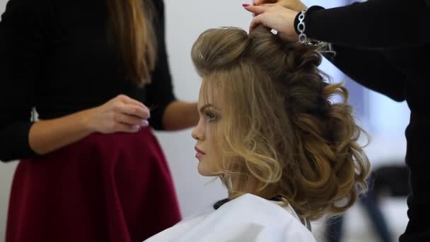 Peluquero hace vestido de pelo hermosa chica en un salón de belleza — Vídeos de Stock