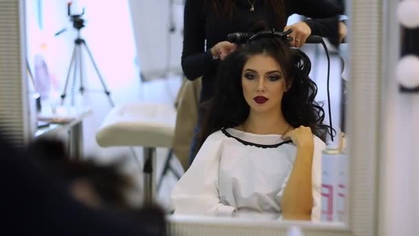 Kadeřnice dělá vlasy krásná dívka šaty v salonu krásy — Stock video