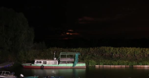 Vista notturna di un porto con la vecchia barca e una luna che sorge sullo sfondo. Time lapse 4k — Video Stock