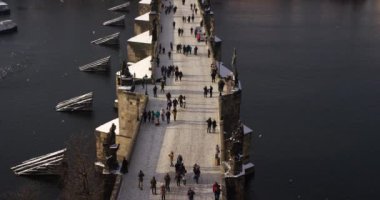 Güneşli bir günde, Çek Cumhuriyeti uzak Prag Kalesi ve Charles Köprüsü üzerinde yürüyen turist. 4k video eğimli, yukarıdan görüntüleme