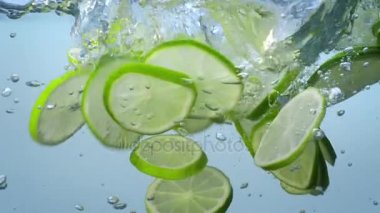 Taze limon dilimleri suya düşmek ve kabarcıklar yavaş hareket ile float.