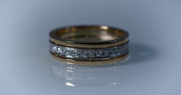 Anillo de oro de boda de diamantes en la macroimagen de superficie de vidrio. Transfusión de luz en anillos . — Vídeos de Stock