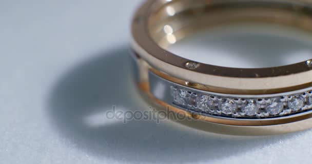 Diamond wedding golden ring macro shot. Transfusion of light on rings. — Stock Video