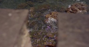 Dalgalar deniz taşlara karşı yendi. Ağır çekim 120 fps. Akdeniz ve taşların küçük dalgalar. 4 k'dan fazla vurdu