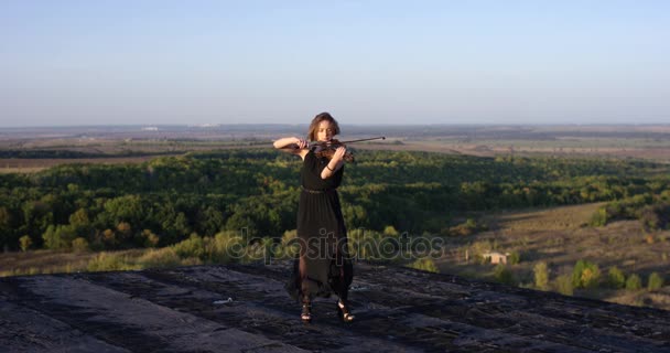 Violoniste fille jouant du violon sur le toit avec fond de ciel . — Video