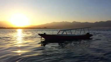 Altın gündoğumu sırasında kıyıya yakın duran teknelerin havadan görünüşü. Endonezya, Gili Havayolları, 2020