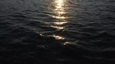 Güneşin doğuşuyla birlikte deniz yüzeyinde alçak seviye uçuş. Güneş doğarken deniz suyu yüzeyinde altın yansımalar