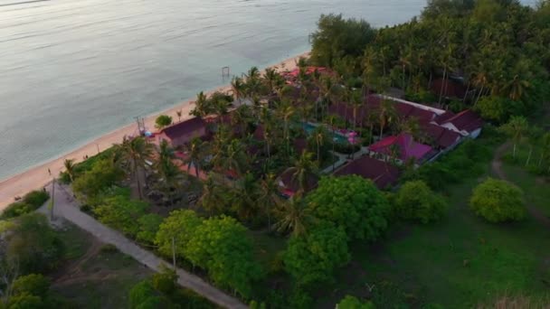 Vista aerea di lussuoso hotel rosa con una grande piscina e bungalow vicino all'oceano . — Video Stock