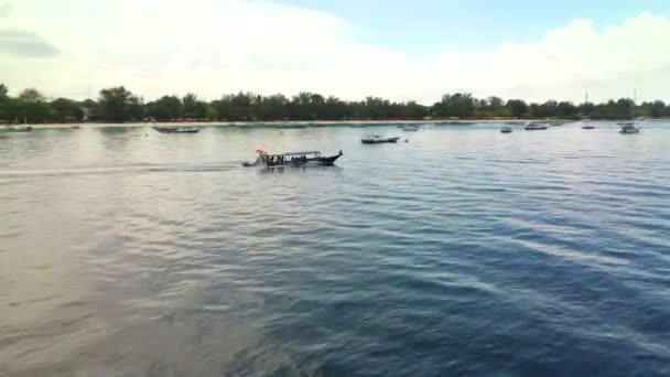 Vista aérea del barco de buceo con equipo y tanques flotando en el agua azul del mar cerca de la isla Gili Trawingan, Indonesia — Vídeo de stock