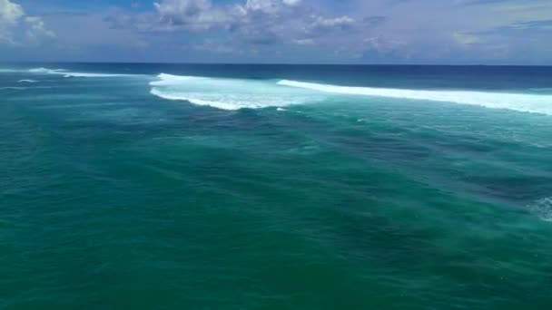 Letecký pohled na velké modré oceánské vlny, které se zřítily za slunečného dne. Bali, Indonésie. — Stock video