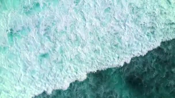 Vista aérea de arriba hacia abajo de las olas del océano estrellándose y espumando. Bali, Indonesia . — Vídeos de Stock