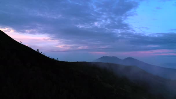 Widok z powietrza na mgliste góry wczesnym rankiem w pobliżu wulkanu Kawah Ijen. Indonezja, Java. — Wideo stockowe