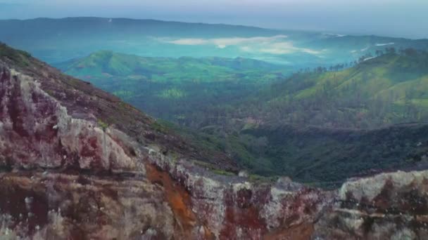 Widok z lotu ptaka wzgórza z górami w tle w pobliżu wulkanu Kawah Ijen. Jawa Wschodnia, Indonezja — Wideo stockowe