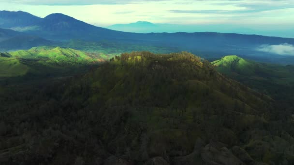 Widok z lotu ptaka wzgórza z górami w tle w pobliżu wulkanu Kawah Ijen. Jawa Wschodnia, Indonezja — Wideo stockowe