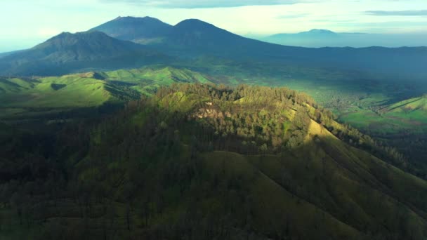 Widok z lotu ptaka wzgórza z górami w tle w pobliżu wulkanu Kawah Ijen. Jawa Wschodnia, Indonezja — Wideo stockowe