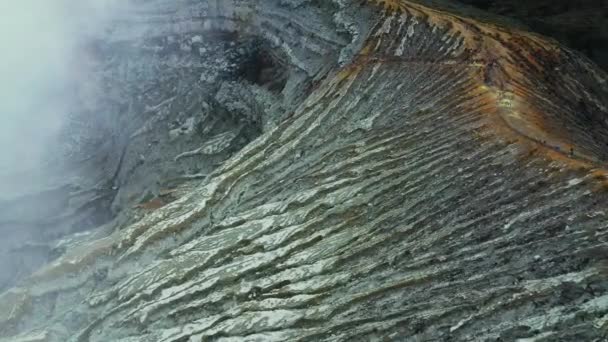 Воздушный вид вулканических пород в горах на фоне вулкана Кава Иджен. Восточная Ява — стоковое видео