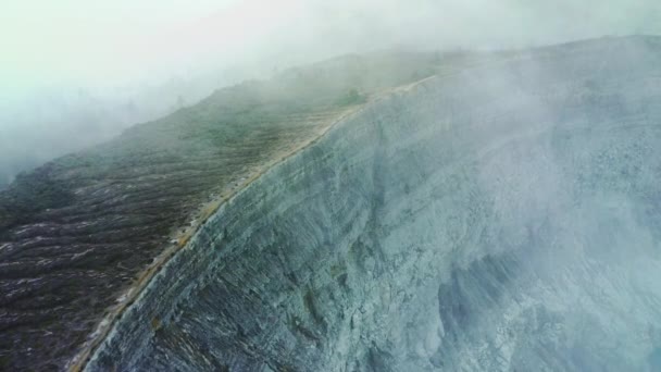 Widok z lotu ptaka wulkanicznych skał w górach na tle wulkanu Kawah Ijen. Jawa Wschodnia, Indonezja — Wideo stockowe