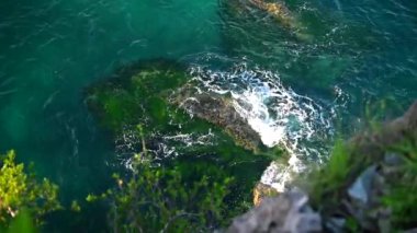 Kayalara çarpan dalgaların üst görüntüsü. Güzel okyanus dalgaları ağır çekim.