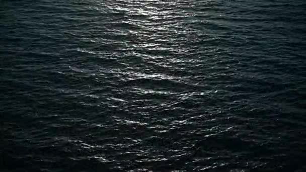 Vagues océaniques au coucher du soleil. Le soleil scintille sur une surface d'eau . — Video
