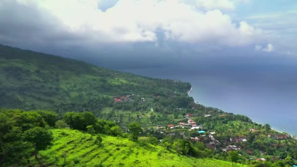 Vista aérea da aldeia de Amed na costa norte da ilha de Bali com pequenos resorts, e uma praia de areia cheia de barcos de pesca balineses tradicionais . — Vídeo de Stock