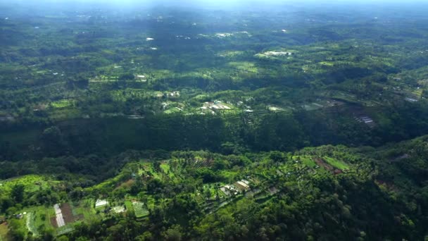 Vídeo aéreo de alta altitude de aldeias de Bali com pacíficos terraços de arroz verde sob as nuvens . — Vídeo de Stock