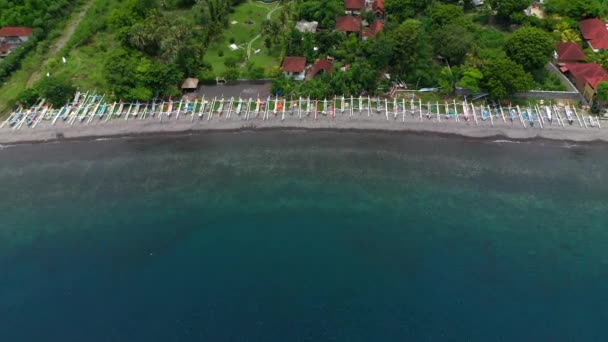 Horní pohled na indonéské dřevěné rybářské lodě ležící na břehu na severu Bali. Zobrazení leteckých dronů. — Stock video