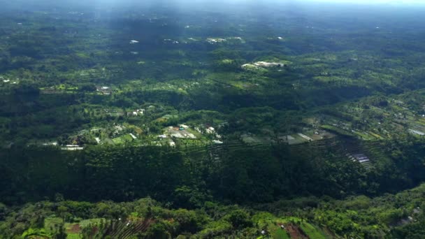 Vídeo aéreo de alta altitude de aldeias de Bali com pacíficos terraços de arroz verde sob as nuvens . — Vídeo de Stock